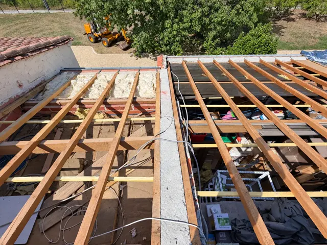Charpente mise à nu avec chevrons pendant une rénovation de toiture